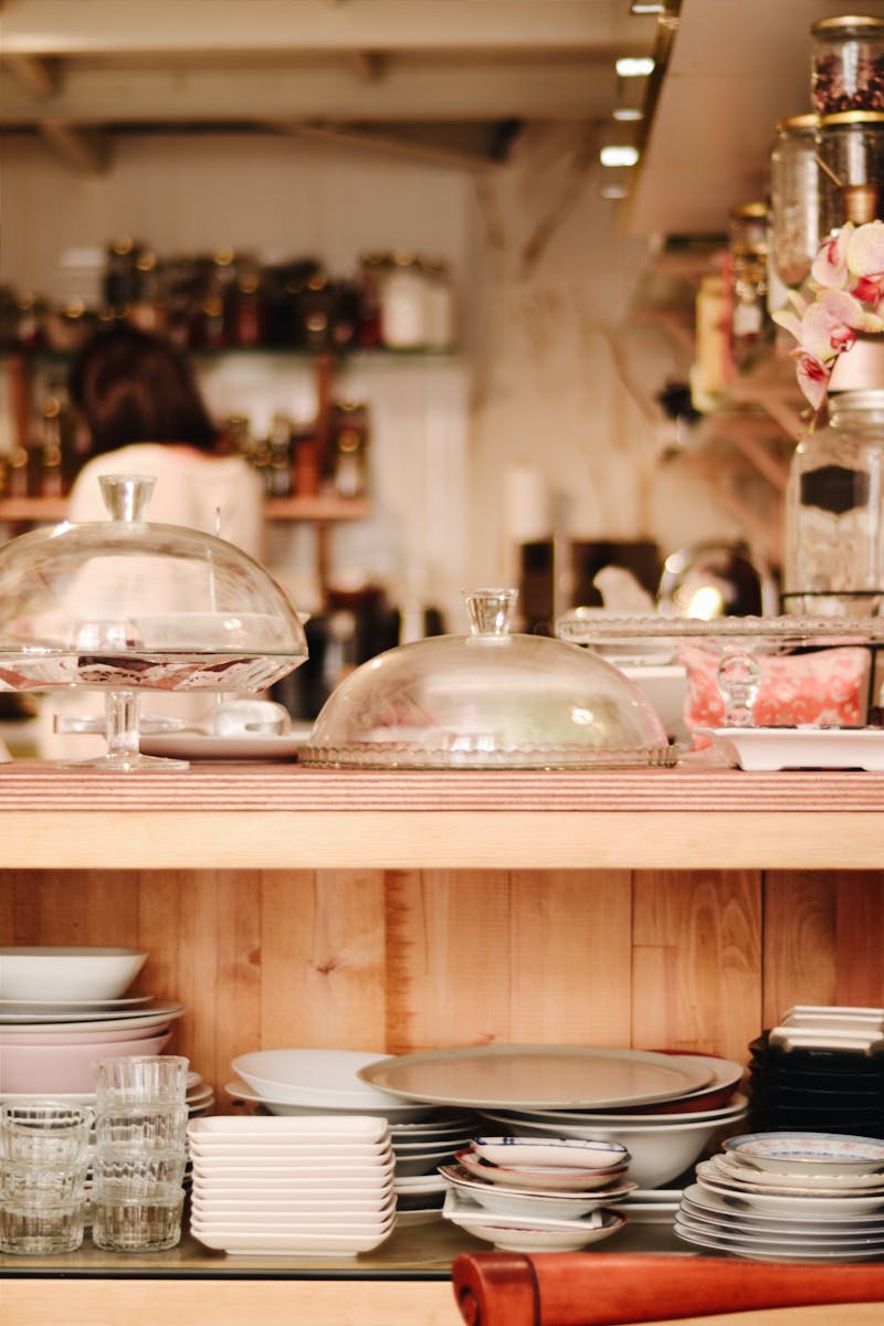 Warm and inviting cafe setting showcasing elegant dinnerware and glassware on a wooden counter.